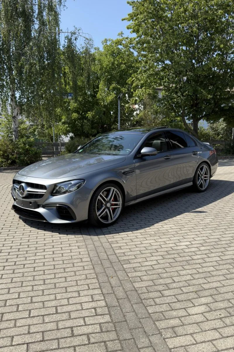 Grauer Mercedes-AMG E 63 S nach der Politur auf dem Hof in der Sonne