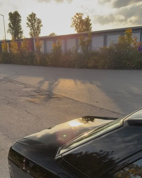 Abendsonne spiegelt sich im Heckdeckel eines Mercedes 190 E
